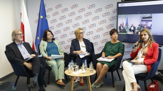 Zdjęcie przedstawiające uczestników II panelu seminarium, siedzących na krzesłach, przy stoliku, od lewej: dr hab. Arwid Mednis, członek Społecznego Zespołu Ekspertów przy prezesie UODO, dr Arleta Nerka, Akademia Leona Koźmińskiego, prowadząca panel dr Dominika Dörre-Kolasa, członkini Społecznego Zespołu Ekspertów przy prezesie UODO, Weronika Kowalik, naczelnik Wydziału Legislacji Departamentu Orzecznictwa i Legislacji UODO, dr hab. Beata Baran-Wesołowska, Uniwersytet Jagielloński.